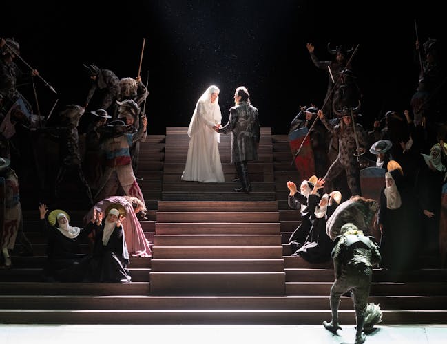 Two performers standing onstage during a performance of Il Trovatore.